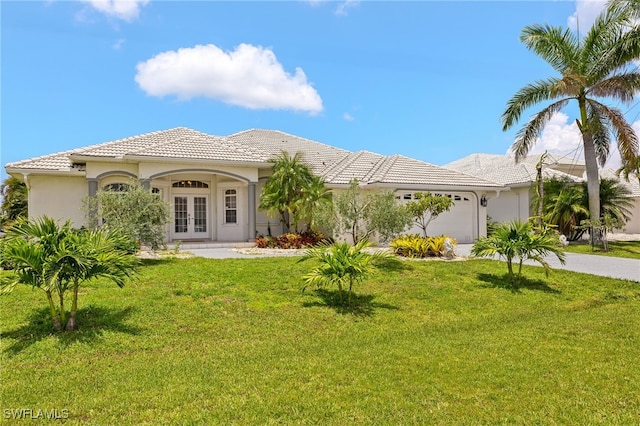 3615 Tripoli Blvd, Punta Gorda, FL 33950 - mediterranean / spanish house with french doors, a garage, a front lawn, a tile roof, and driveway