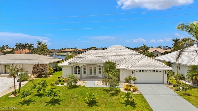 3615 Tripoli Blvd, Punta Gorda, FL 33950 - view of front of property featuring french doors, a tiled roof, an attached garage, and a front lawn