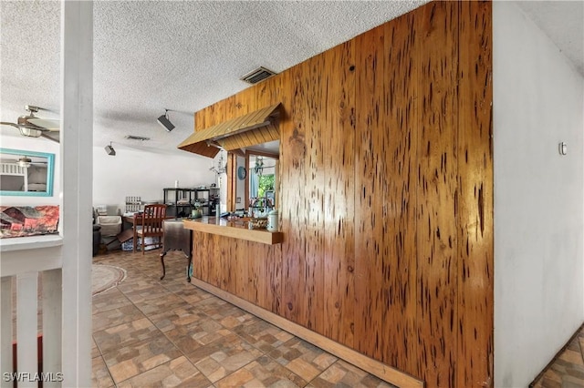 17041 Tarpon Way N, Fort Myers, FL 33917 - kitchen featuring a textured ceiling and wood walls
