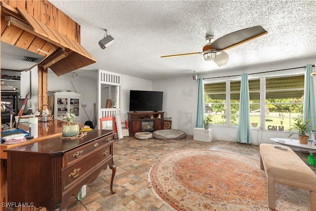 17041 Tarpon Way N, Fort Myers, FL 33917 - living room with a ceiling fan, a textured ceiling, and stone finish floors