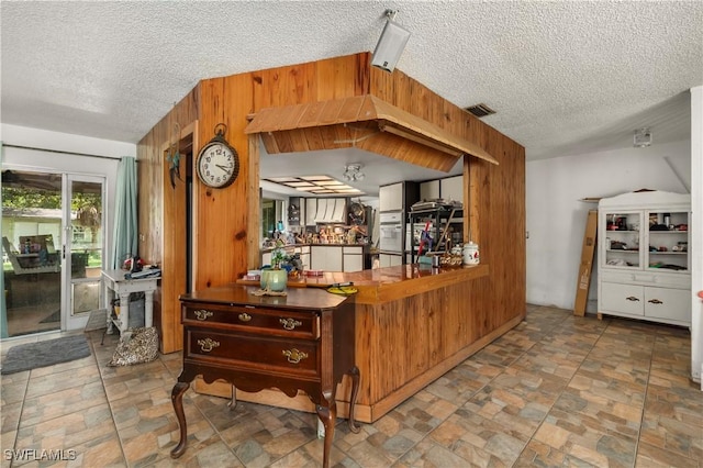 17041 Tarpon Way N, Fort Myers, FL 33917 - bar area with wooden walls, stone finish flooring, and a textured ceiling