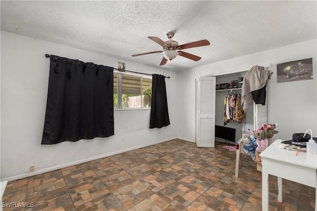 17041 Tarpon Way N, Fort Myers, FL 33917 - bedroom with a textured ceiling, a closet, ceiling fan, and stone finish flooring