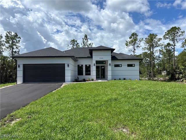 2342 10th Ave SE, Naples, FL 34117 - prairie-style home with asphalt driveway, an attached garage, a front lawn, and stucco siding