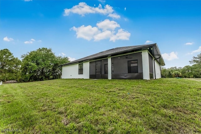 1220 Edward Ave, Lehigh Acres, FL 33972 - back of house with a sunroom, a lawn, and stucco siding