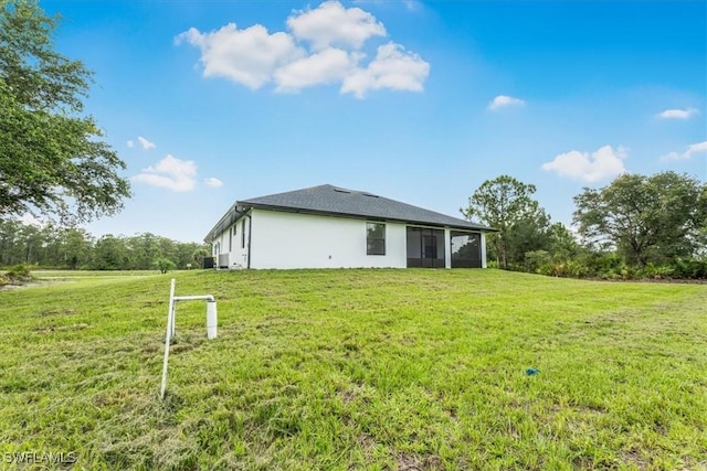 1220 Edward Ave, Lehigh Acres, FL 33972 - back of house with a sunroom, a yard, and stucco siding