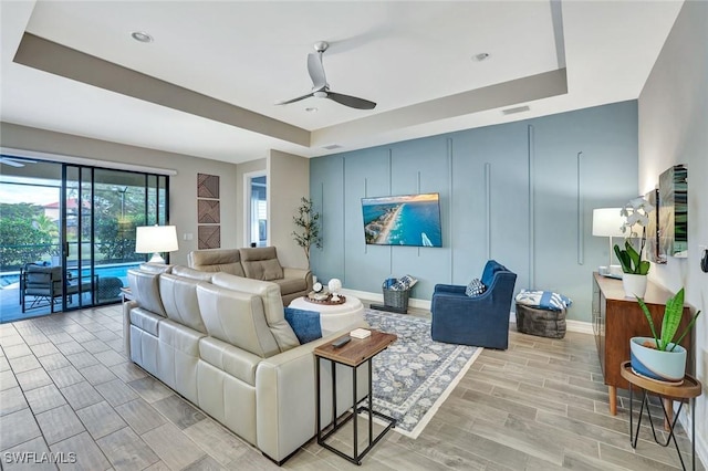 14384 Tuscany Pointe Cv, Naples, FL 34120 - living area with a tray ceiling, ceiling fan, and wood tiled floors