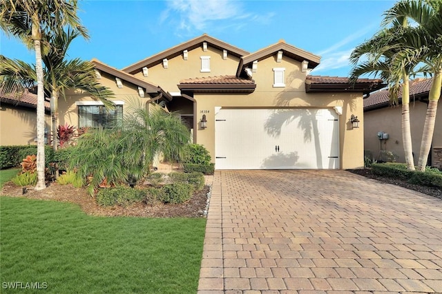 14384 Tuscany Pointe Cv, Naples, FL 34120 - mediterranean / spanish house featuring stucco siding, decorative driveway, an attached garage, a front lawn, and a tile roof