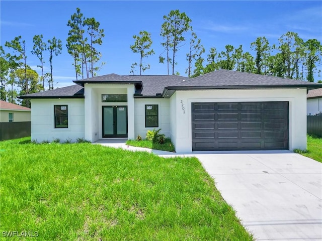 3202 21st St W, Lehigh Acres, FL 33971 - view of front of home featuring french doors, an attached garage, concrete driveway, a shingled roof, and stucco siding