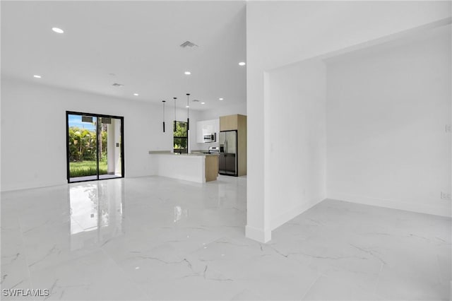 3202 21st St W, Lehigh Acres, FL 33971 - unfurnished living room featuring light marble finish flooring and recessed lighting