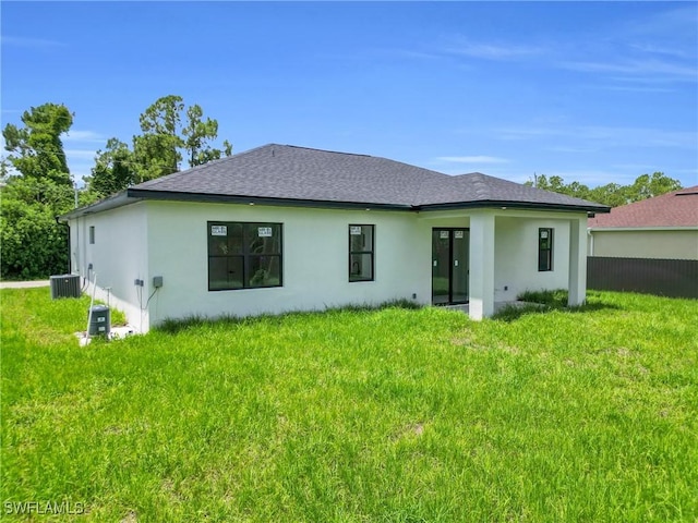3202 21st St W, Lehigh Acres, FL 33971 - rear view of property featuring a lawn, stucco siding, and a shingled roof