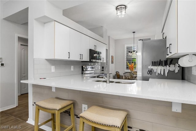 3760 Sawgrass Way Unit 3514, Naples, FL 34112 - kitchen with a peninsula, stainless steel appliances, backsplash, and light countertops
