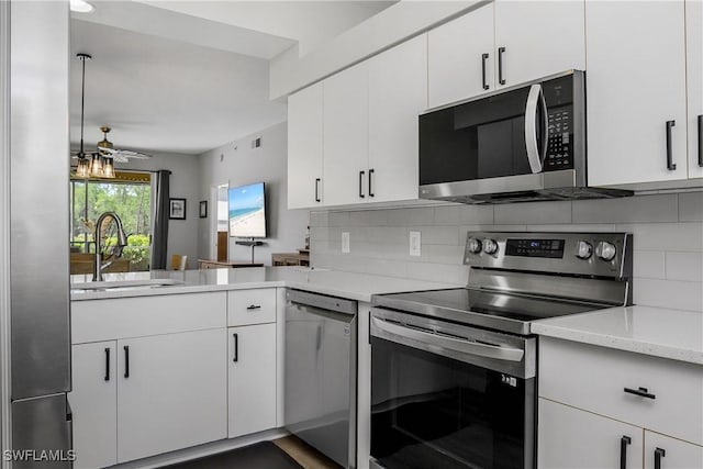 3760 Sawgrass Way Unit 3514, Naples, FL 34112 - kitchen with appliances with stainless steel finishes, backsplash, white cabinets, and a peninsula