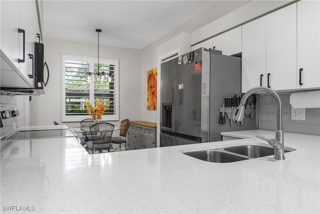 3760 Sawgrass Way Unit 3514, Naples, FL 34112 - kitchen with stainless steel appliances, hanging light fixtures, white cabinetry, decorative backsplash, and light stone countertops