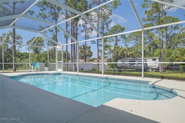 601 Clayton Ave, Lehigh Acres, FL 33972 - outdoor pool featuring a lanai, a patio, and view of scattered trees