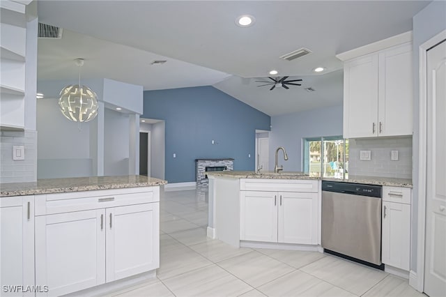 601 Clayton Ave, Lehigh Acres, FL 33972 - kitchen featuring stainless steel dishwasher, a peninsula, a stone fireplace, tasteful backsplash, and white cabinets