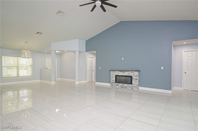 601 Clayton Ave, Lehigh Acres, FL 33972 - unfurnished living room featuring ceiling fan, a chandelier, a stone fireplace, high vaulted ceiling, and light tile patterned floors