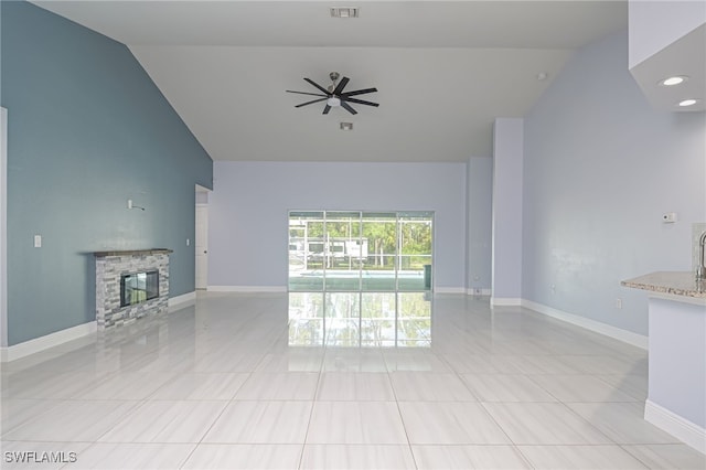 601 Clayton Ave, Lehigh Acres, FL 33972 - unfurnished living room featuring high vaulted ceiling, a stone fireplace, light tile patterned flooring, and a ceiling fan
