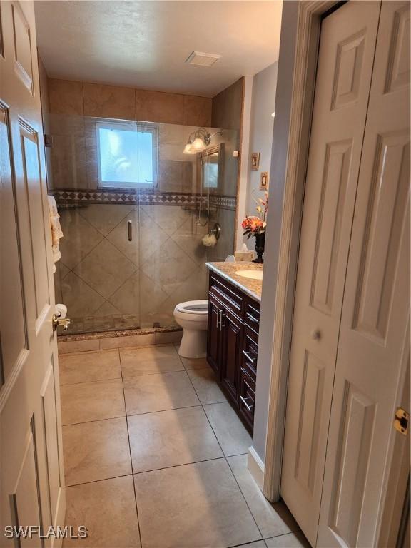 1240 Shady Rest Ln Unit 104, Naples, FL 34103 - bathroom with tile patterned flooring, vanity, and a shower stall