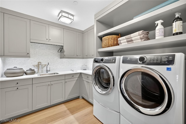 13925 Old Coast Rd Unit 403, Naples, FL 34110 - washroom with washing machine and dryer, light wood-type flooring, and cabinet space