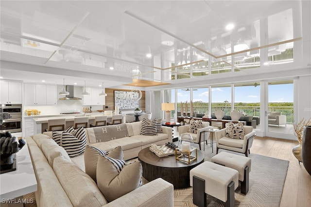 13925 Old Coast Rd Unit 403, Naples, FL 34110 - living room featuring light wood finished floors, a towering ceiling, and recessed lighting