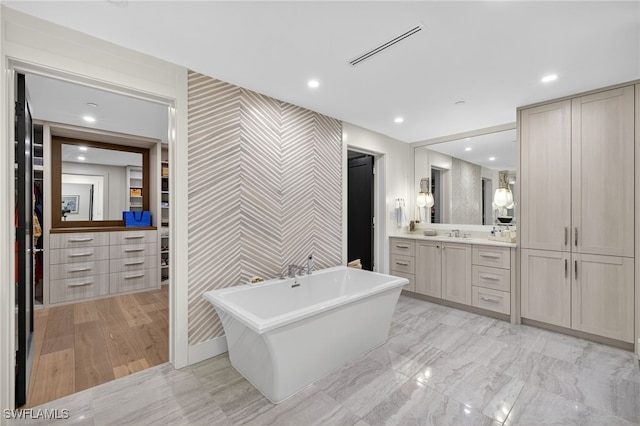 13925 Old Coast Rd Unit 403, Naples, FL 34110 - full bath featuring an accent wall, wallpapered walls, a freestanding bath, vanity, and a spacious closet