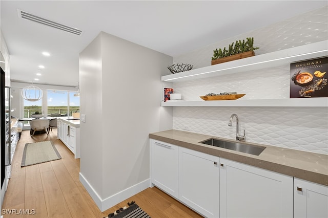 13925 Old Coast Rd Unit 403, Naples, FL 34110 - indoor wet bar featuring light wood finished floors, decorative backsplash, and recessed lighting