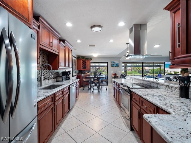 1431 SW 53rd Ln, Cape Coral, FL 33914 - kitchen with appliances with stainless steel finishes, island exhaust hood, decorative backsplash, light tile patterned floors, and recessed lighting