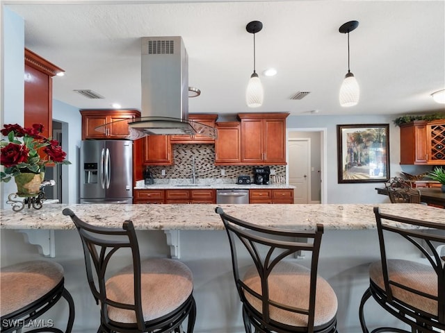 1431 SW 53rd Ln, Cape Coral, FL 33914 - kitchen featuring stainless steel appliances, island exhaust hood, backsplash, hanging light fixtures, and a kitchen bar