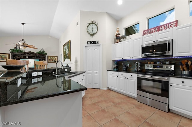 1962 Terrazzo Ln, Naples, FL 34104 - kitchen with appliances with stainless steel finishes, lofted ceiling, backsplash, white cabinets, and light tile patterned flooring