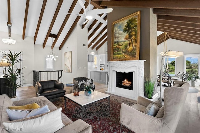 5850 Pelican Bay Blvd Unit C, Naples, FL 34108 - living room with beamed ceiling, a warm lit fireplace, wood finished floors, and high vaulted ceiling