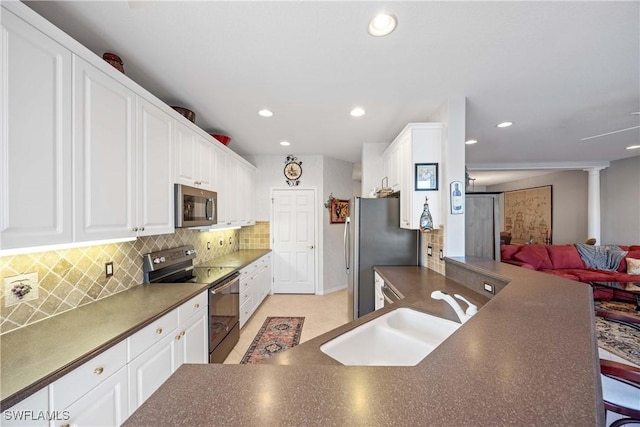 4660 Winged Foot Ct Unit 104, Naples, FL 34112 - kitchen with stainless steel appliances, dark countertops, open floor plan, tasteful backsplash, and white cabinets