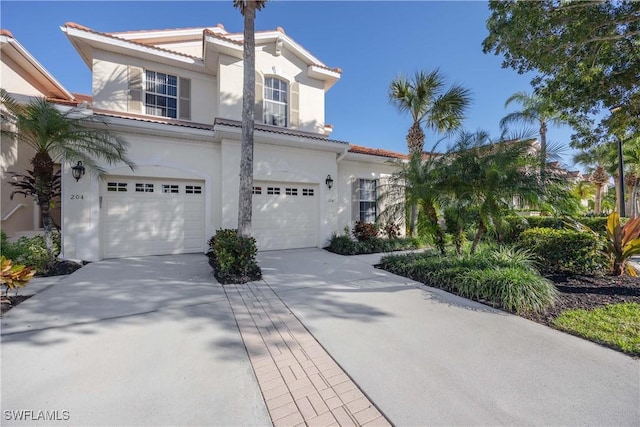 4660 Winged Foot Ct Unit 104, Naples, FL 34112 - mediterranean / spanish-style house with an attached garage, a tiled roof, stucco siding, and driveway