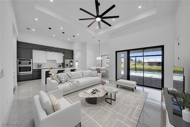 1405 SW 28th Ter, Cape Coral, FL 33914 - living room with a towering ceiling, recessed lighting, a raised ceiling, a ceiling fan, and a chandelier