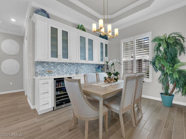 15904 Talon Ter, Punta Gorda, FL 33982 - dining room with beverage cooler, wood finish floors, a chandelier, crown molding, and recessed lighting