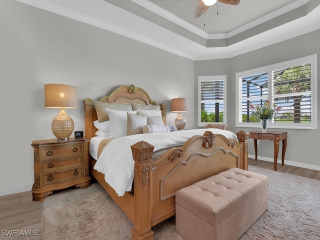 15904 Talon Ter, Punta Gorda, FL 33982 - bedroom with light wood-style flooring, crown molding, a tray ceiling, and a ceiling fan