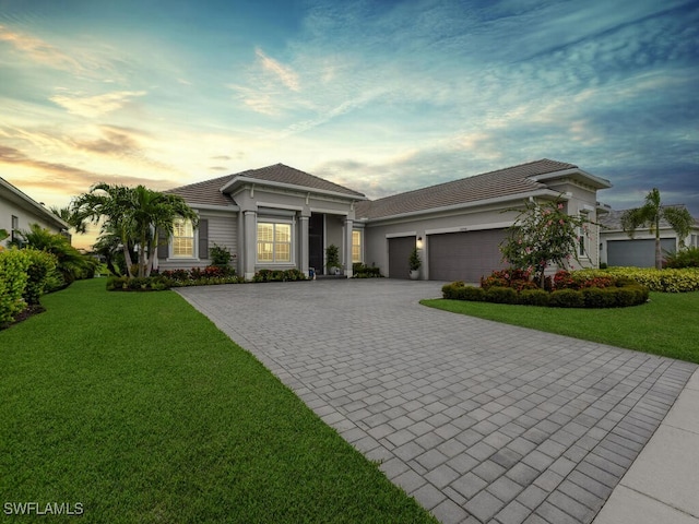 15904 Talon Ter, Punta Gorda, FL 33982 - view of front of home featuring a lawn, decorative driveway, an attached garage, and a tile roof