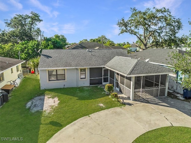 27924 Quinn St, Bonita Springs, FL 34135 - rear view of property featuring a sunroom, roof with shingles, a lawn, and driveway