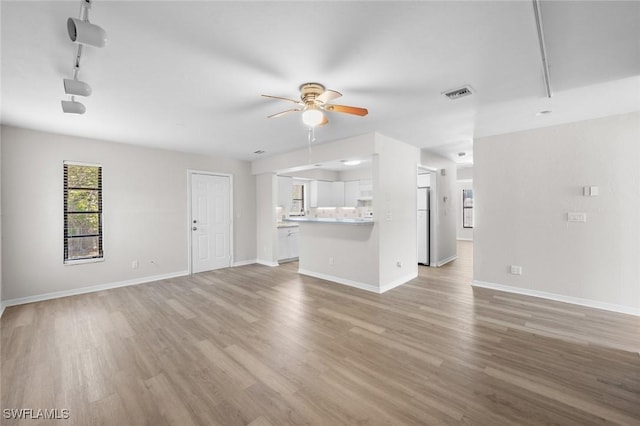27924 Quinn St, Bonita Springs, FL 34135 - unfurnished living room with ceiling fan, light wood-style floors, and rail lighting