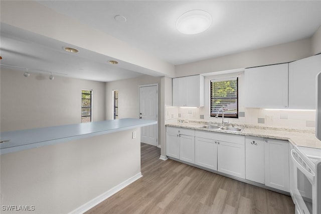27924 Quinn St, Bonita Springs, FL 34135 - kitchen featuring healthy amount of natural light, stove, white cabinetry, and light wood-style flooring