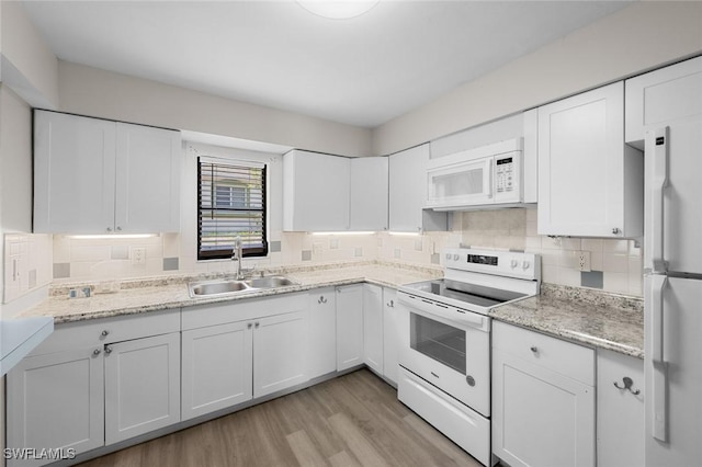 27924 Quinn St, Bonita Springs, FL 34135 - kitchen featuring white appliances, white cabinets, tasteful backsplash, light wood finished floors, and light stone counters