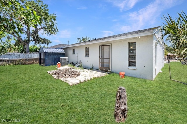 27924 Quinn St, Bonita Springs, FL 34135 - rear view of house with stucco siding, a fenced backyard, a storage shed, and a patio area