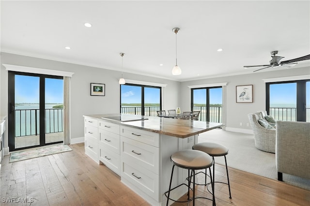 1100 S Collier Blvd Unit 723, Marco Island, FL 34145 - kitchen with a breakfast bar, open floor plan, white cabinets, recessed lighting, and decorative light fixtures