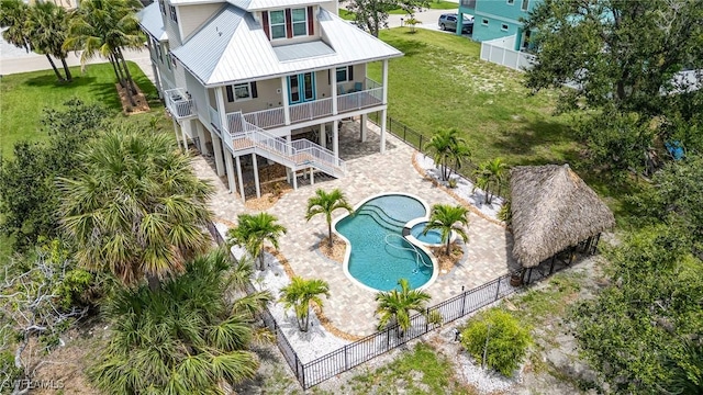 830 San Carlos Dr, Fort Myers Beach, FL 33931 - back of property with a metal roof, a fenced backyard, stairway, and a porch