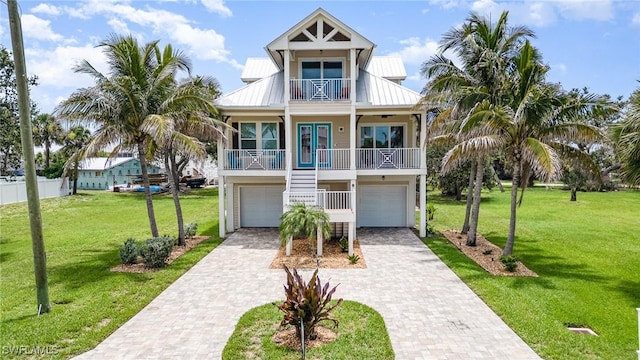 830 San Carlos Dr, Fort Myers Beach, FL 33931 - coastal home with a balcony, decorative driveway, a garage, and a front yard