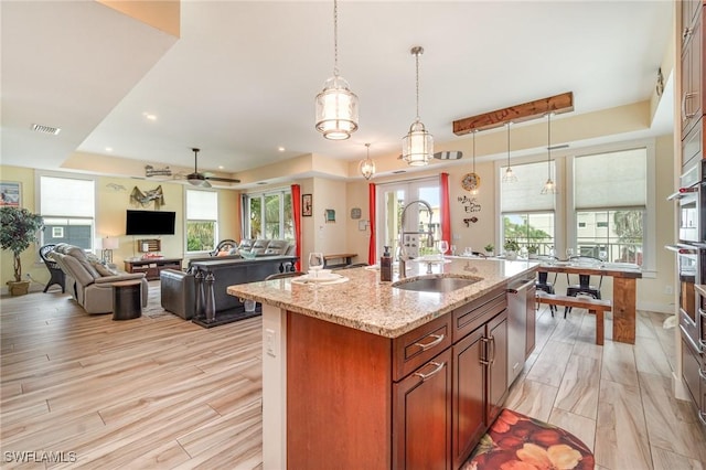 830 San Carlos Dr, Fort Myers Beach, FL 33931 - kitchen with a raised ceiling, light stone counters, hanging light fixtures, an island with sink, and open floor plan