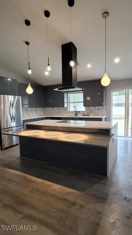 1614 SW 27th St, Cape Coral, FL 33914 - kitchen featuring freestanding refrigerator, island exhaust hood, a kitchen island, backsplash, and light countertops