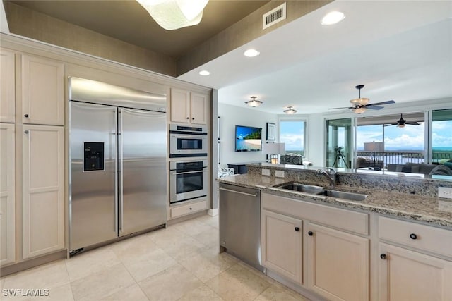 275 Indies Way Unit 1001, Naples, FL 34110 - kitchen with stainless steel appliances, light tile patterned flooring, light stone countertops, healthy amount of natural light, and recessed lighting