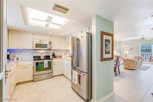 4531 Bay Beach Ln Unit 337, Fort Myers Beach, FL 33931 - kitchen featuring stainless steel appliances, ceiling fan, light tile patterned floors, decorative backsplash, and a skylight