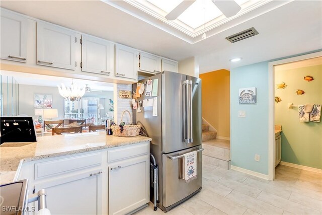 4531 Bay Beach Ln Unit 337, Fort Myers Beach, FL 33931 - kitchen with freestanding refrigerator, ceiling fan, white cabinetry, light tile patterned floors, and light stone countertops