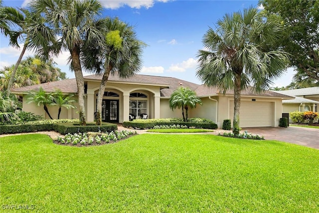 2322 River Reach Dr, Naples, FL 34104 - view of front of home featuring french doors, stucco siding, a front lawn, a garage, and driveway